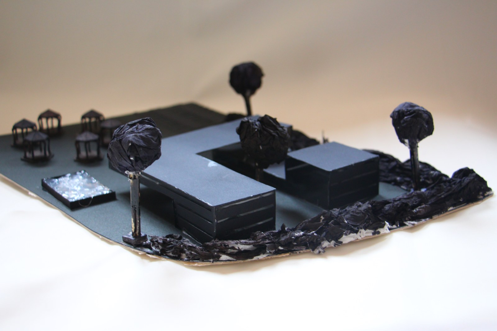 Black-and-white site model with separate building volumes and trees
