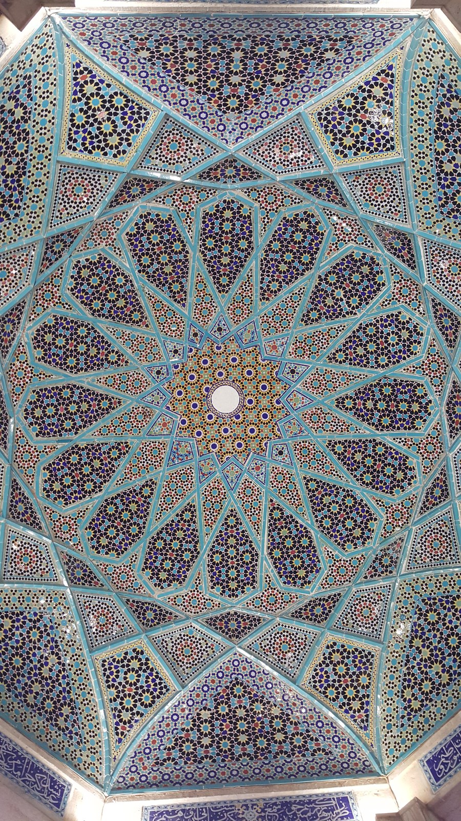 Geometric mosaic pattern across a decorated vaulted ceiling