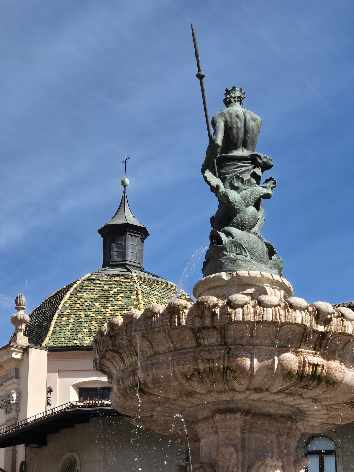 Sculpted fountain figure against a blue sky
