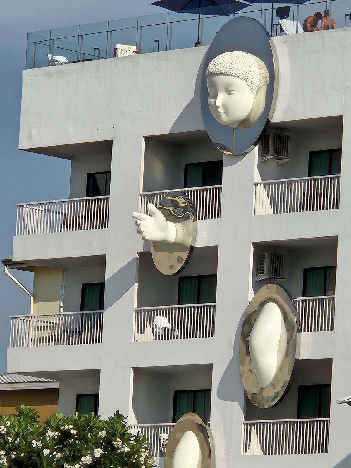 Sculpted faces integrated into a modern building facade